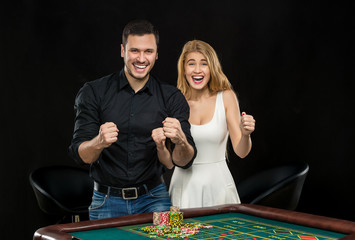 Young couple celebrating win at roulette table in casino. 