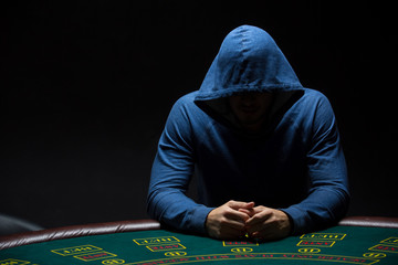 Portrait of a professional poker player sitting at pokers table 