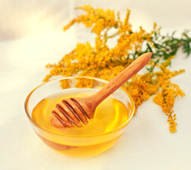 Honey and wooden spoon decorated with flowers