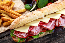 Fried Potatoes and Sandwich with lettuce, slices of fresh tomatoes, salami, hum and cheese.