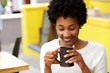 © mimagephotos - Happy young black woman drinking coffee