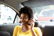 © mimagephotos - African woman in a car talking on mobile phone