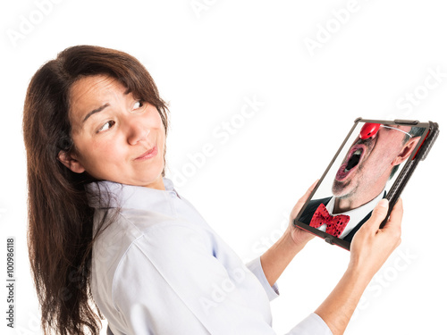 фотографія Photograph of a young mixed race woman reacting to an angry clown in a business suit screaming from the screen of her device