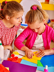 Portrait of group kids craft colored paper  in kindergarten .