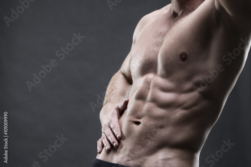Fotografía Handsome muscular bodybuilder posing on gray background