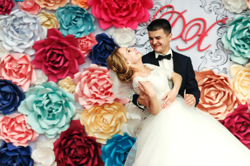 Canvas Print - Happy emotional wedding couple holding hands and smiling groom a