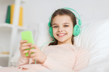 Poster - happy girl lying in bed with smartphone at home