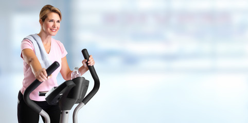 Poster - Mature woman doing exercise on elliptical trainer.