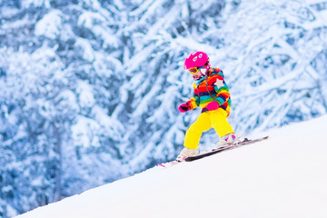 Wall Mural - Little girl skiing in the mountains