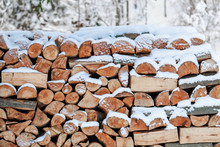 Stacked Firewood And Covered With Snow