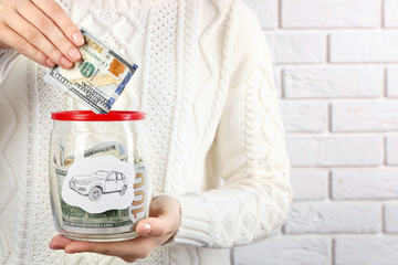 Wall Mural - Woman hands with money in glass jar, close up