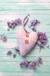 Decorative heart  and fresh lilac flowers  on turquoise painted