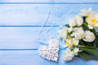 White tulips and narcissus flowers and decorative heart  on blue