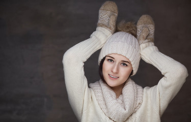 Wall Mural - A girl in warm pullover and fur winter hat.