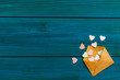 blue wooden background for Valentine's day with pink hearts in the envelope