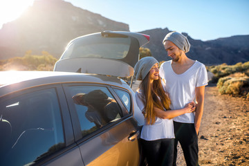 Young couple travelers having fun near the car