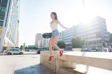 Young Beautiful Asiatic Woman Skater Jumping From A Wall, Listen