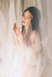 portrait shot of a beautiful girl with perfect skin and elegant hair.Cute young girl sitting in a veil and sad.Beautiful melancholy.Fashionable toning.creative computer colors.