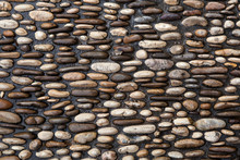 Cobbled Pavement Made Of River Rounded Pebbles. Background Textu