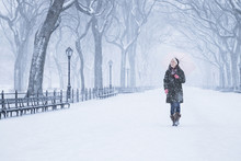 Asian Woman Walking In Snowy Park