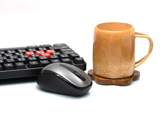 black computer mouse with keyboard and wood cup on white backgro