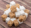 © akulamatiau - White sugar and brown sugar cane cube over wooden background