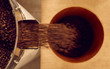 Overhead shot of roasted coffee beans falling into container