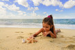 little girl playing with a starfish on the beach