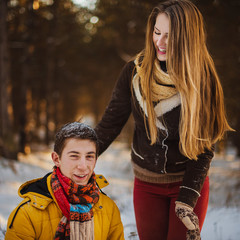 Couple play in winter with snow and sledges