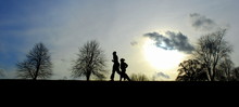 Winter Landscape With Silhouettes Of Runners On A Horizon At Sunset