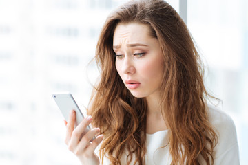 Poster - Sad woman holding smartphone