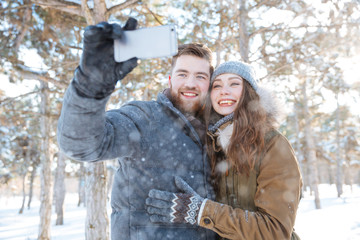 Poster - Couple making photo on smartphone in winter park