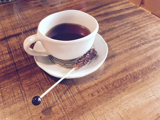 Cup of hot tea with sugar stick