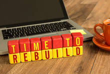 Time To Rebuild Written On A Wooden Cube In A Office Desk