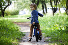 Happy Boy Ride A Bicycle In City Park