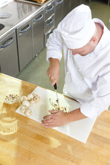 Wall Mural - Professional chef preparing mushrooms in large kitchen