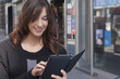 © patrisyu - Young woman holding a tablet on the street
