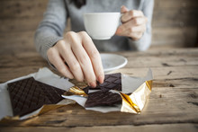Woman Is Eating A Chocolate Bar And Coffee