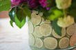 Vase with lime and beatiful flowers against a white tablecloth 