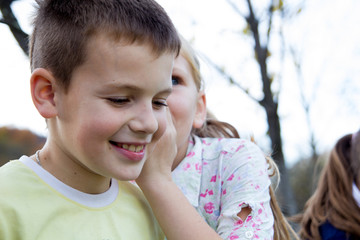 Little girl and boy whispering