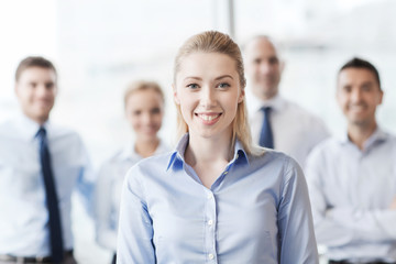 Sticker - smiling businesswoman with colleagues in office