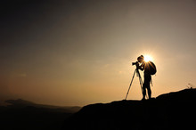 Woman Photographer Taking Photo On Sunset Mountain Peak