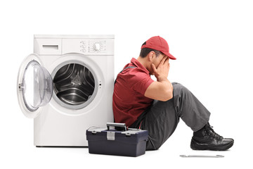 Poster - Disappointed worker sitting by a washing machine