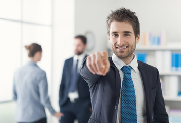 Wall Mural - Smiling businessman pointing at camera