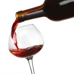 Wall Mural - Red wine pouring in glass, isolated on white