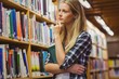 © WavebreakMediaMicro - Thoughtful student looking at bookshelf