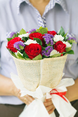 Woman holding a bouquet of roses in hand for Valentine's Day , b