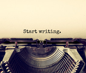 close up image of typewriter with paper sheet and the phrase: start writing . copy space for your te