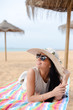 © gorosi - Elegant young pretty lady lying on a beach towel