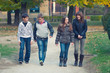 © Solid photos - Happy teenage boys and girls walking in spring park